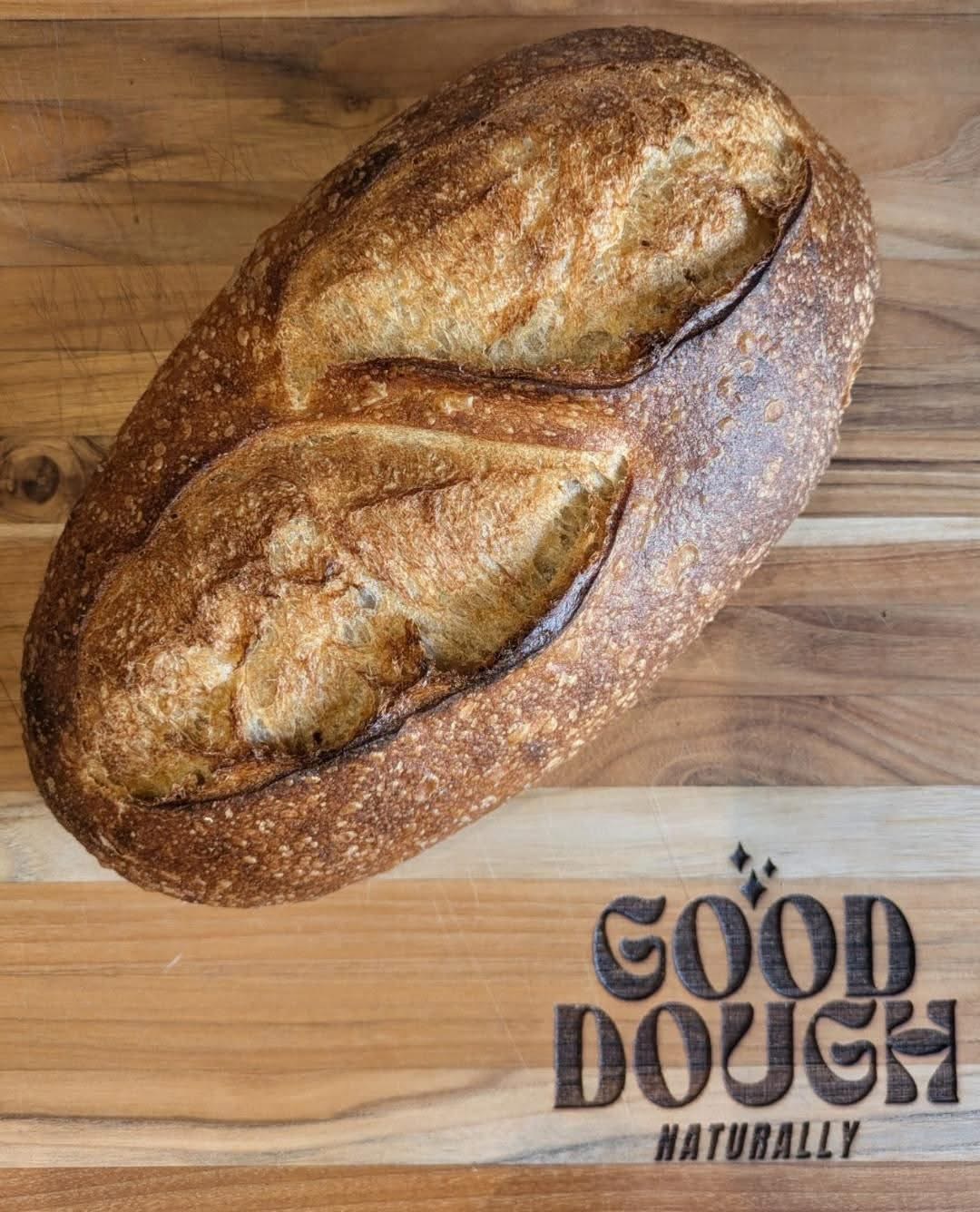 Good Dough loaf on a branded cutting board
